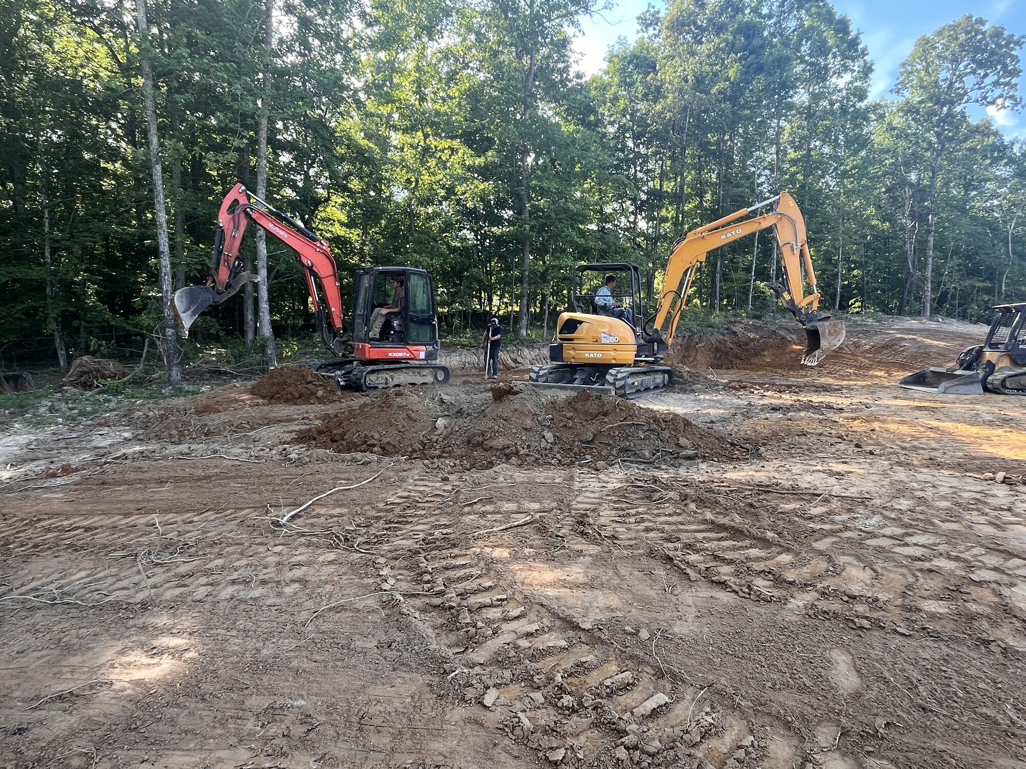 Two excavators on site prep for a new build near Selmer TN