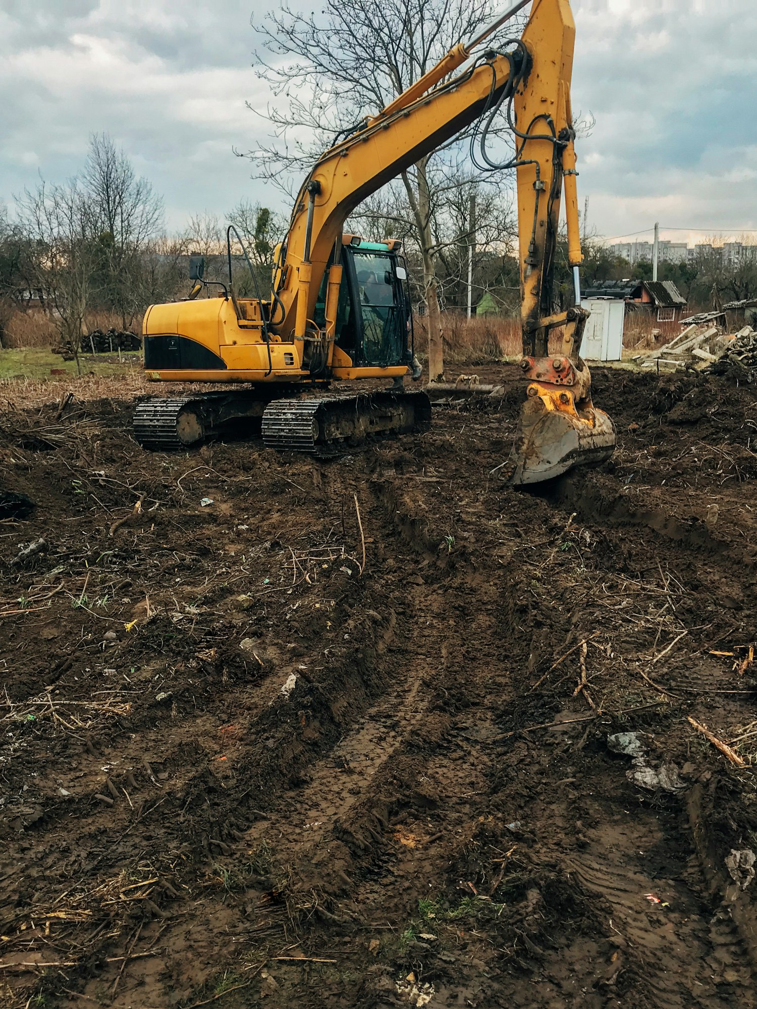 Bulldozer clearing land from old trees, roots and branches with dirt and trash